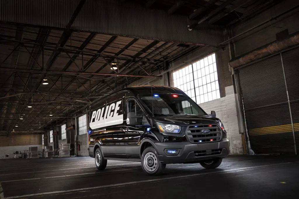 Black high-roof Ford Transit in police livery configured for prisoner transport