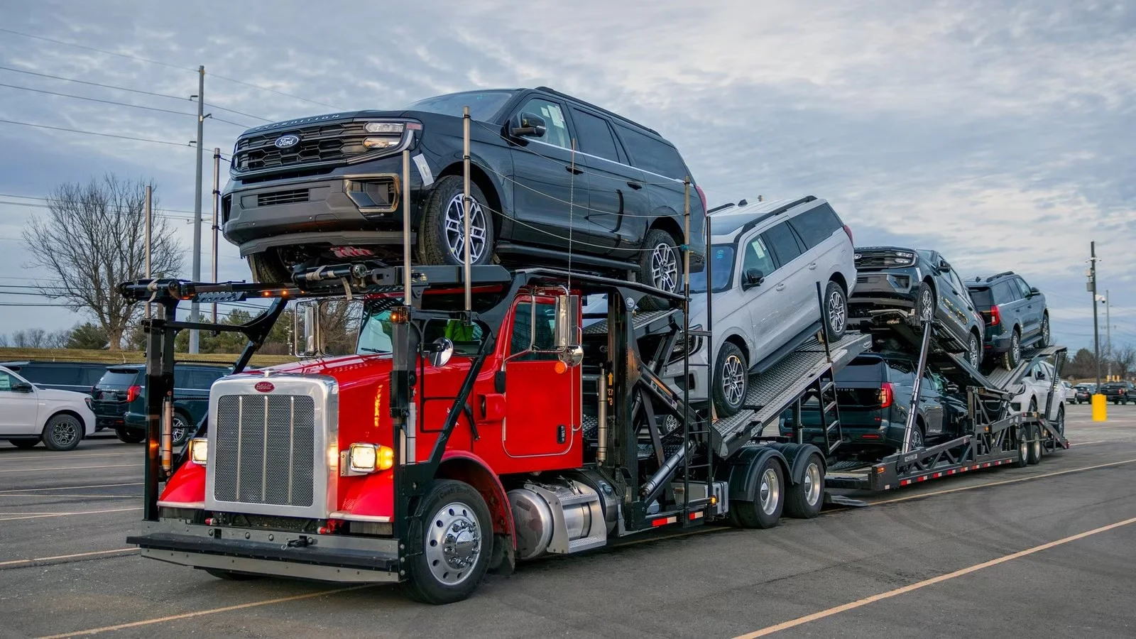 Car hauler loaded with Ford Expeditions arriving for fleet delivery at Envision Ford