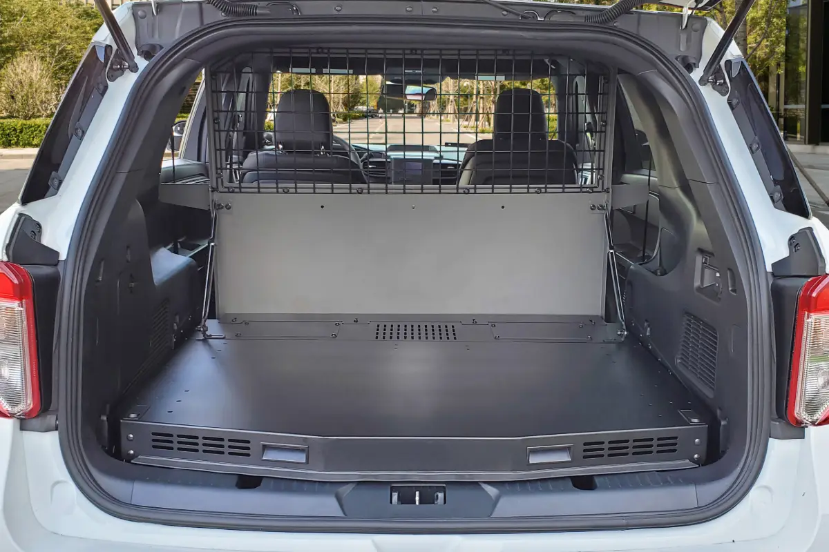 Ford Police Interceptor Utility with the rear hatch open, showing a steel prisoner partition behind the second row and a flat cargo platform