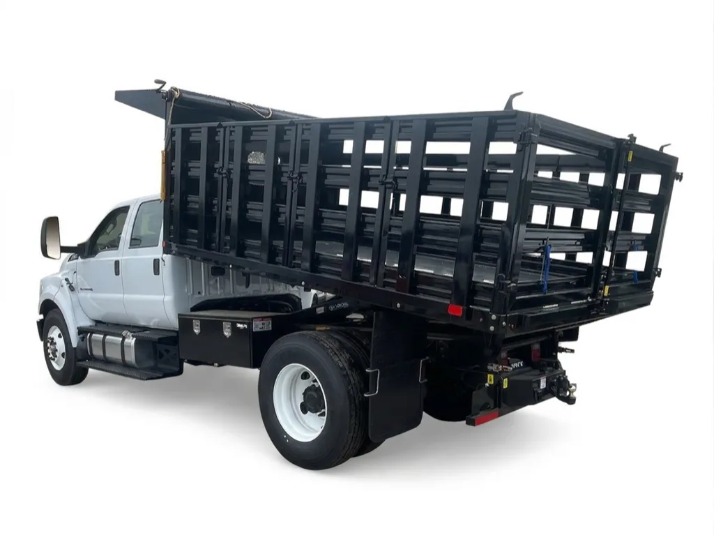 Ford chassis cab with a raised dump body, fold-down sides tilted for unloading
