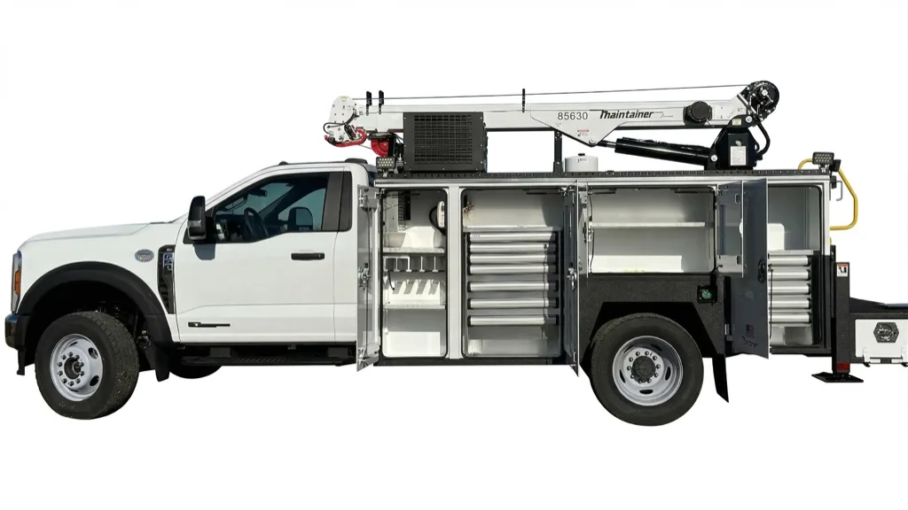 Ford F-550 mechanics service body with every compartment open showing drawers and tool trays, plus a telescoping crane